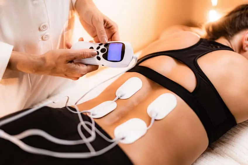 Dispositivo de electroterapia (TENS) en acción, utilizado para reducir el dolor asociado a la hernia discal.